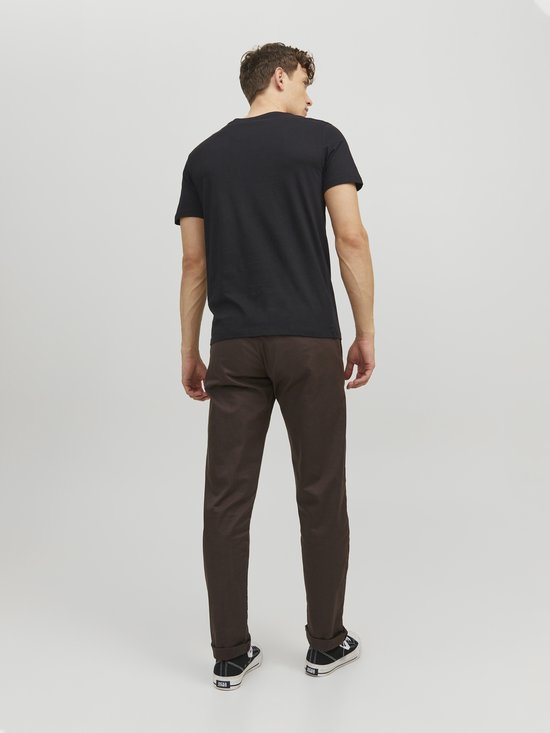 Man met de rug naar de camera, met zwart T-shirt met witte JACK & JONES-opdruk en bruine broek.