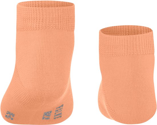 Twee zalmkleurige sokken met een geribbelde boord. Eén sok heeft grijze anti-slip nopjes op de zool.