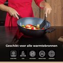Vrouw in rood kookt groenten in een wokpan op een fornuis. Geschikt voor alle warmtebronnen.