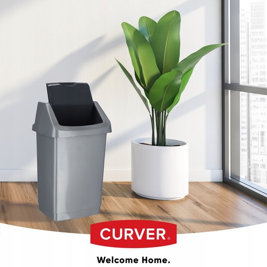 Poubelle Curver argentée avec couvercle gris à côté d'une grande plante en pot blanc.