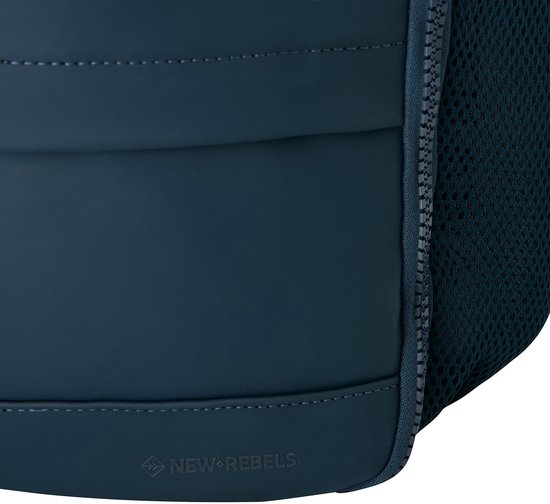 Detail van de zijkant van een marineblauwe rugzak met mesh en 'NEW REBELS' logo.