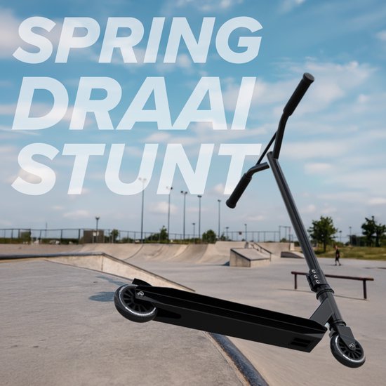 Zwarte stuntstep in een skatepark onder een blauwe hemel. "SPRING DRAAI STUNT".
