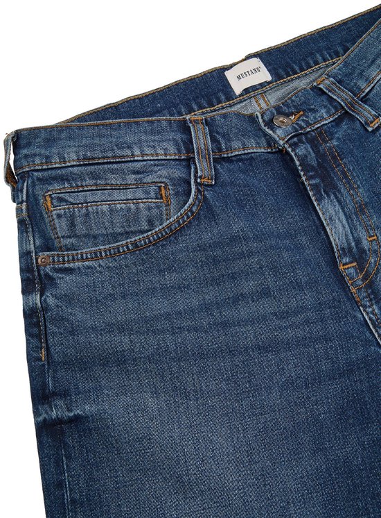 Sluiting en zakdetail van een blauwe jeans met het Mustang logo.