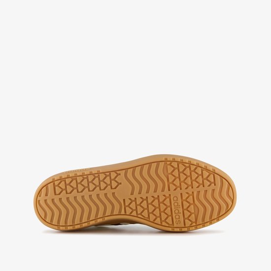 Onderkant van een witte damessneaker met bruine plateauzool en Adidas-logo. Het zoolprofiel heeft golvende en geometrische patronen.