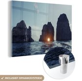 MuchoWow® Glasschilderij 60x40 cm - Schilderij acrylglas - Zonsondergang bij de rotsen in de zee in Capri - Foto op glas - Schilderijen