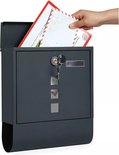 Une main insère des lettres dans une boîte aux lettres murale grise avec serrure et encoches carrées.