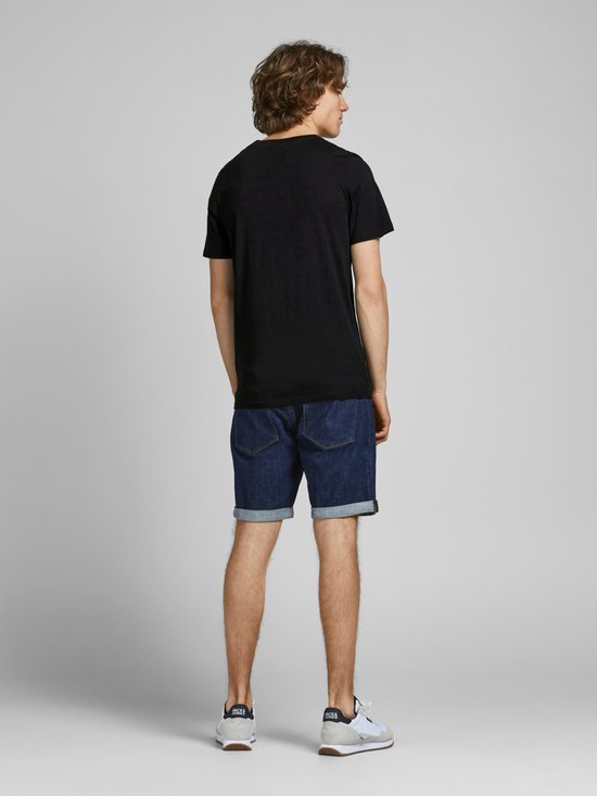 Achterkant van een zwart Jack & Jones t-shirt met korte mouwen, gedragen door een man met spijkerbroek en sneakers.