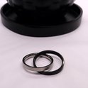 Zilverkleurige en zwart matte ringen die in elkaar grijpen.