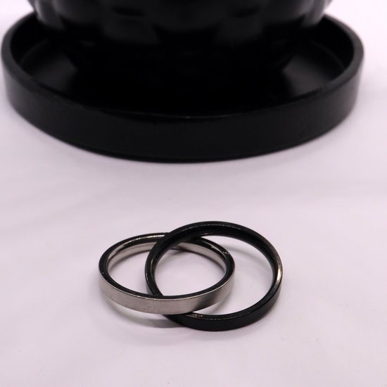 Zilverkleurige en zwart matte ringen die in elkaar grijpen.