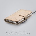 Étui de téléphone doré texturé, placé sur un chargeur sans fil.