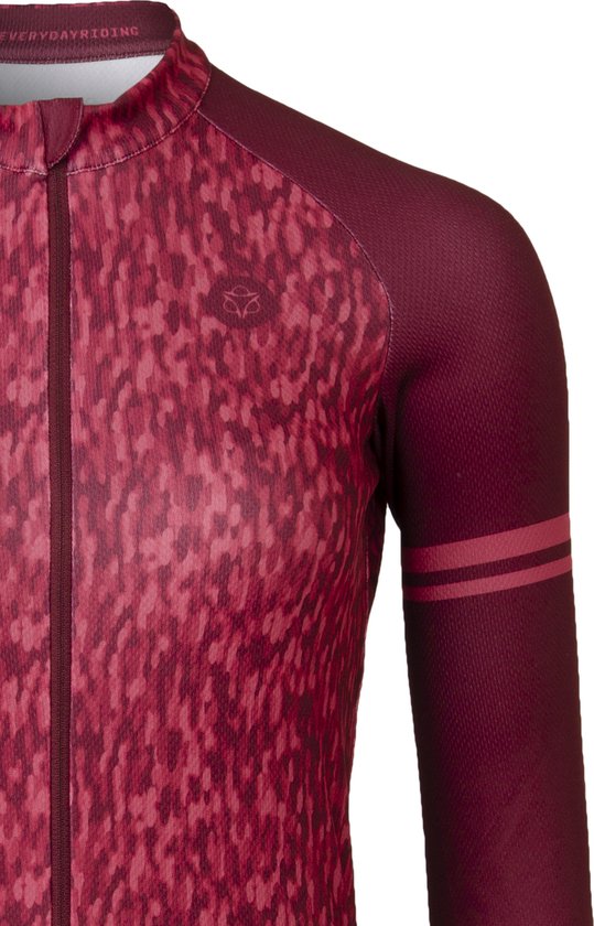 Detail van een rood fietsshirt met lange mouwen met een abstract patroon in roodtinten en dubbele rode strepen op de linkermouw.
