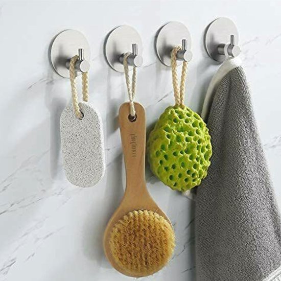 Zilverkleurige haakjes met een ronde schijfbevestiging, drie met een loofah en een met een handdoek.