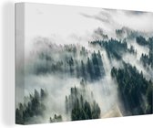 Canvas Schilderij Dichte mist tussen de naaldbomen - 90x60 cm - Wanddecoratie