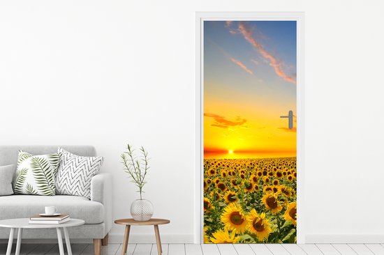 Zonnebloemenveld bij zonsondergang, oranje lucht met wolken.