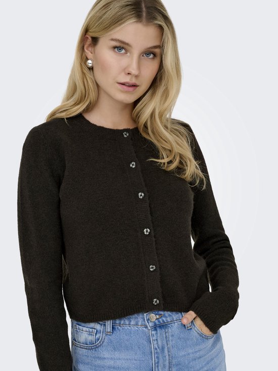 Model met donkerbruin vest met ronde hals, knoopsluiting, gecombineerd met jeans.