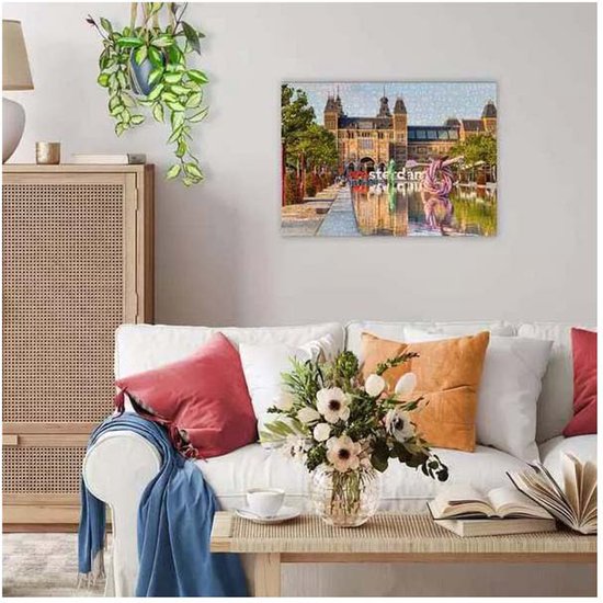 Een woonkamer met een canvas aan de muur van het Rijksmuseum in Amsterdam, met de tekst 'I amsterdam'.