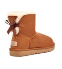 Cognackleurige enkellaarsjes van suède met witte schapenwollen voering, strikdetail en UGG-logo op de achterkant.