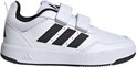 Witte Adidas sneaker met klittenbandsluiting, zwarte strepen en een zwarte zool.