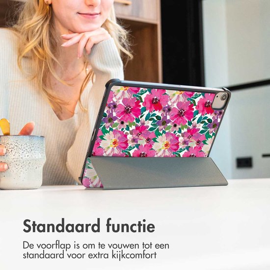 Een vrouw met een tablet hoes met bloemenprint, in standaard functie.