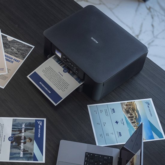 Zwarte Brother printer op een donker bureau, papier wordt uit de printer gevoerd, met documenten eromheen.