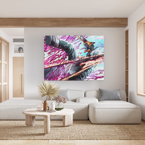 Een lichte woonkamer met een grote stoffen bank, een ronde salontafel en een canvas schilderij van een anime figuur met een kettingzaag.