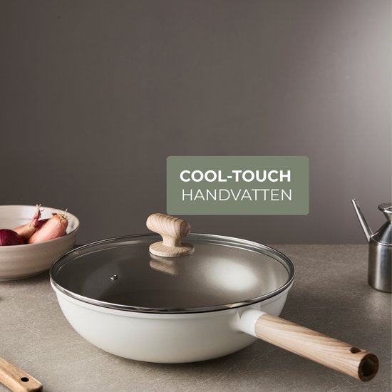 Wok blanc avec couvercle en verre et poignée en bois, avec le texte 'Poignées Cool-touch'.