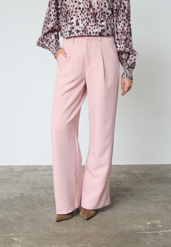 Lichtroze wijde broek met plooien aan de voorkant, gedragen door een model met een blouse met luipaardprint.