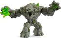 Woedend stenen monster figuur met groene kristallen in zijn vuist, met geopende mond en groene ogen.