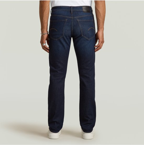 Donkerblauwe G-Star jeans, gedragen door een man. Zicht op de achterkant. G-Star Originals label zichtbaar.