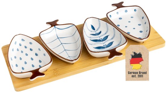 Vier witte, bladvormige dipschaaltjes met blauwe patronen: polkadots, takken en bladeren, op een bamboe dienblad met vier uitsparingen.