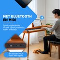 Jongeman speelt digitale piano met houten afwerking, met Bluetooth en MIDI voor leer-apps.