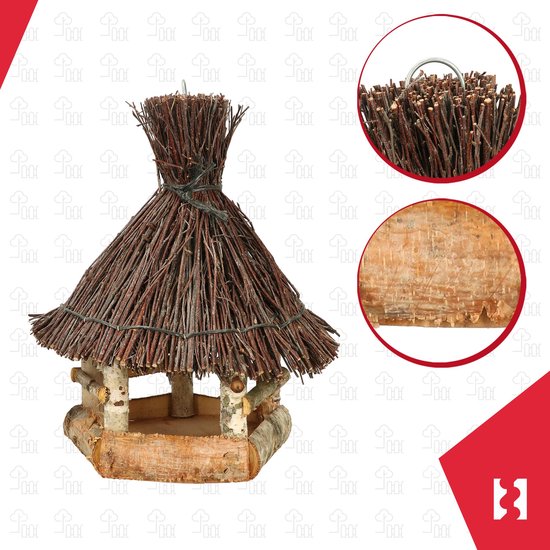 Detailopname van het rieten dak en de ruwe bast van het houten vogelhuisje.