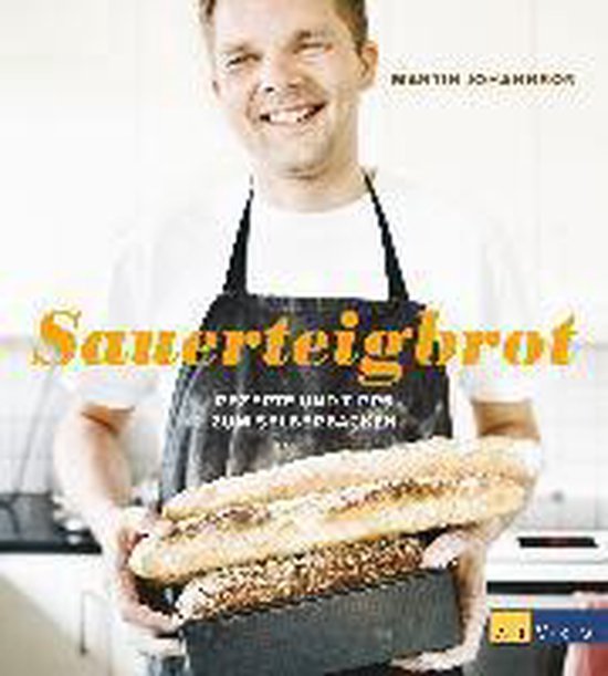 Kookboekcover met lachende man in schort die versgebakken zuurdesembroden vasthoudt. Titel: Sauerteigbrot.