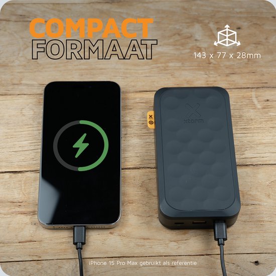 Zwarte Xtorm powerbank naast een iPhone 15 Pro Max, illustrerend het compacte formaat 143 x 77 x 28mm.