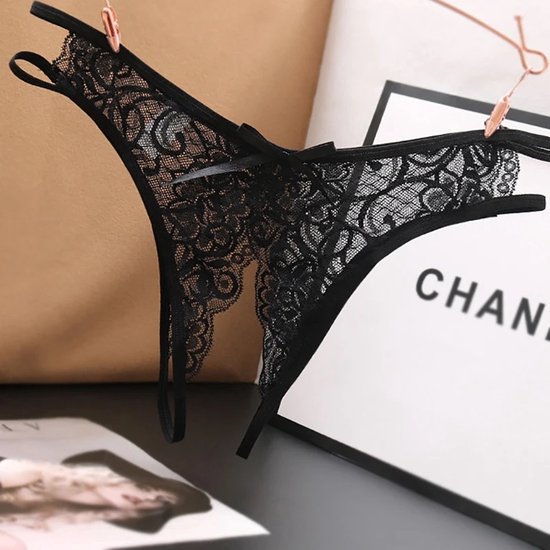 String noir en dentelle avec nœud et entrejambe ouvert, suspendu à des pinces à linge.