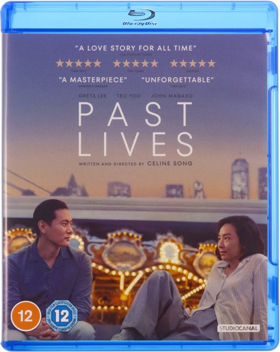 Voorkant van de Blu-ray hoes van "Past Lives". Twee mensen zitten tegenover elkaar met een carrousel op de achtergrond. Film titel prominent aanwezig.