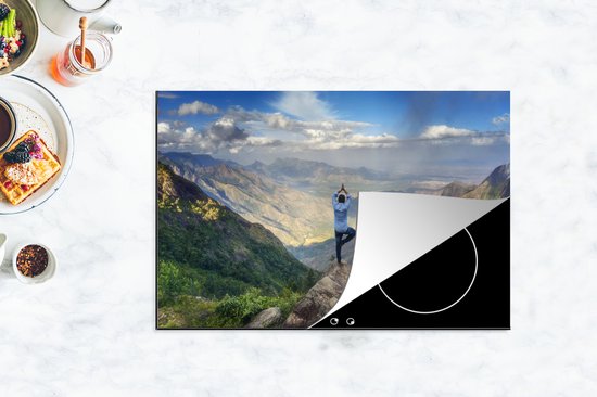 KitchenYeah® Inductie beschermer 83x51.5 cm - Een man neemt een yogahouding aan op een bergtop - Kookplaataccessoires - Afdekplaat voor kookplaat - Inductiebeschermer - Inductiemat - Inductieplaat mat