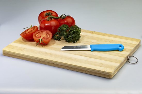 Een blauw Solingen schilmesje op een houten snijplank, naast tomaten en peterselie.