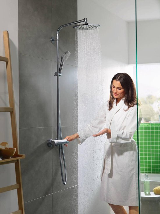 Vrouw met witte badjas onder de douche met regendouche