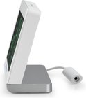 Zijaanzicht van een wit digitaal weerstation met een gekanteld groen display, staand op een zilveren voet.