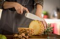 Chef snijdt ananas met Tefal mes. Walnoten liggen ernaast.