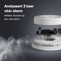 Gedemonteerde witte rook- en koolmonoxidemelder die de interne componenten en sensoren toont, met rook die eromheen zweeft.