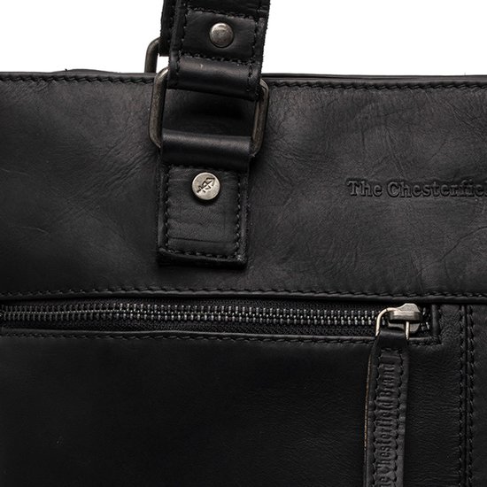 Close-up van de voorkant van een zwarte leren tas met rits en logo.