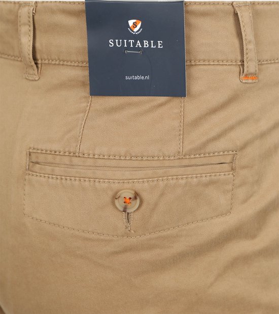 Zakdetail van een lichtbruine chino broek met oranje stiksels en knoop.
