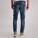 Achterkant van een man in een blauwe spijkerbroek met lichte wassing en een leren merklabel op de achterkant.