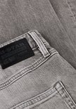 Close-up van het zwarte G-Star Originals Raw Denim label op een grijze jeans.
