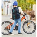 Jongen met rugzak met blauwe en grijze camouflageprint en cartoon jongen, staand naast zijn fiets.