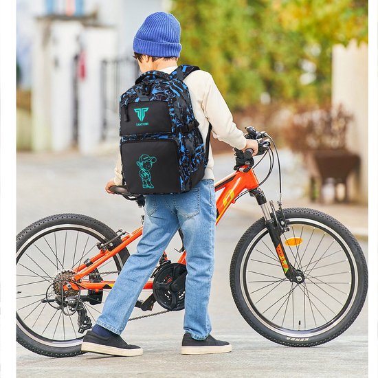 Jongen met rugzak met blauwe en grijze camouflageprint en cartoon jongen, staand naast zijn fiets.