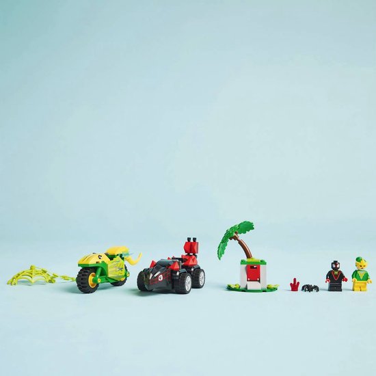 Groene LEGO-motor, rode LEGO-racewagen, palmboom, spinnenweb en minifiguren op blauwe achtergrond.