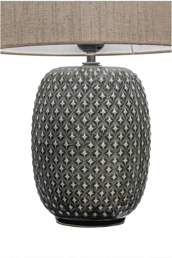 Grijze tafellamp met een beige stoffen kap en een decoratieve, geribbelde voet met ruitpatroon.